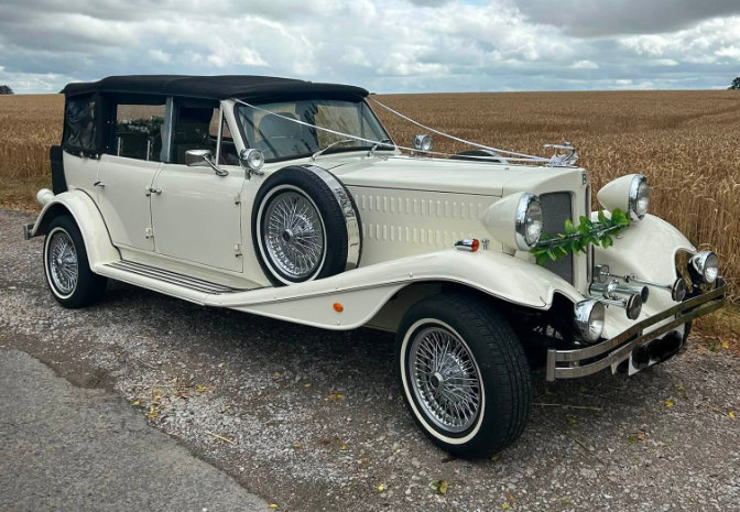 Ivory Beauford tourer dressed with white ribbons beside a cornfield